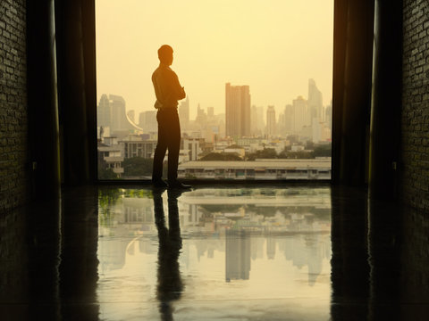 Businessman looking at city through window