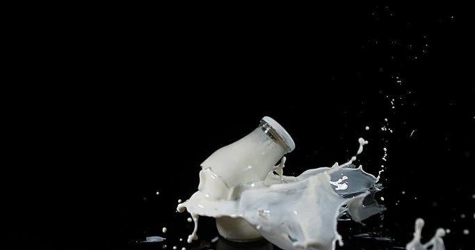 Bottle of Milk Exploding against Black Background, slow motion 4K
