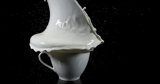 Bowl with Exploding Milk against Black Background, slow motion 4K