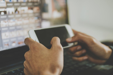 hand with mobile phone and laptop