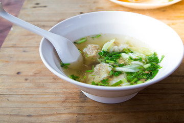 Wonton soup with spoon in a bowl. Traditional asian food