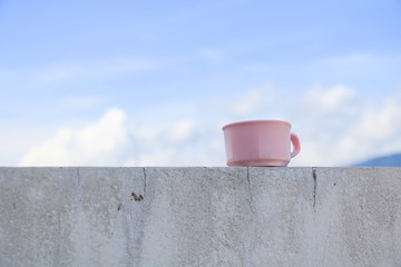 coffee cup pink on the floor with  blue sky background