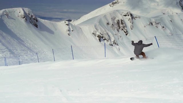 Active man snowboarder riding on slope.
