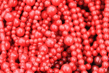 Red wooden beads as stylish red embossed background with painted wood texture