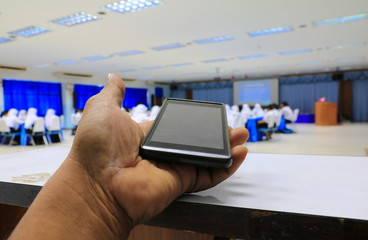 smartphone hand holding  in seminar conference classroom: Select focus with shallow depth of field.