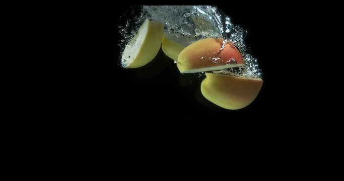 Apples, malus domestica, Fruit entering Water against Black Background, Slow Motion 4K