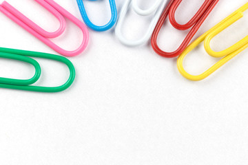 Colored clips on white paper, with nice paper texture