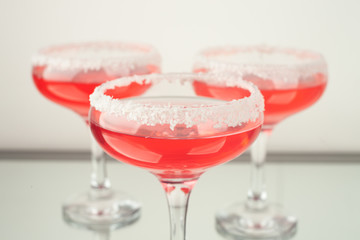 pink lady cocktails on glass decorated with coconut, party background, front view