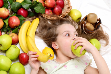 Fototapeta na wymiar little happy girl or cute hungry child eating colorful fruit