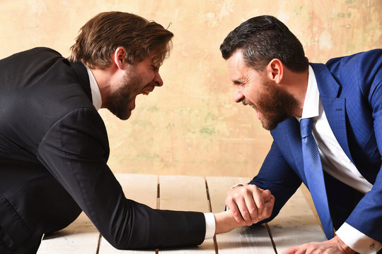 arm wrestling of businessman and aggressively compete man