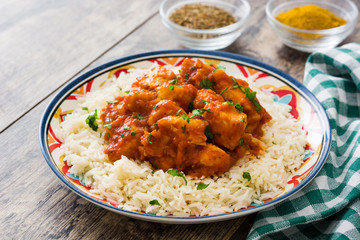 Chicken tikka masala with rice on wooden background

