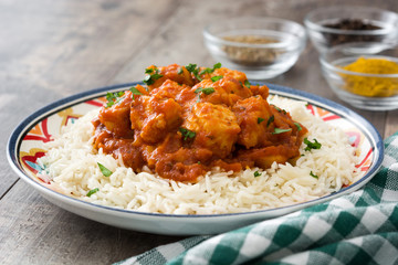 Chicken tikka masala with rice on wooden background

