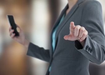 Obraz premium Midsection of businesswoman holding smartphone 