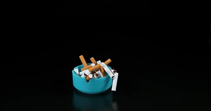 Ashtray and Cigarettes Falling against Black Background, Slow Motion 4K