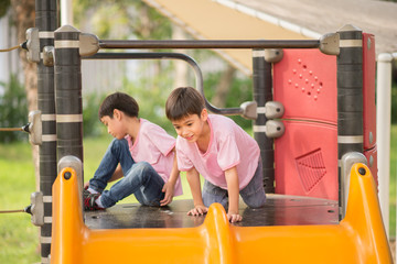 Fototapeta na wymiar Little boys playing slider at playground