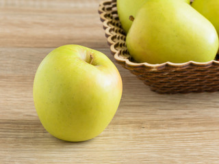 Yellow apples in a basket on the table.