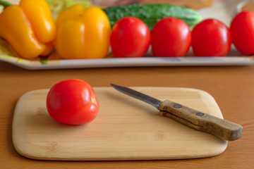Tomatoes and cucumbers and peppers cutting board on the table.