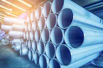 Stainless steel pipes on warehouse in steel construction industry. Selective focus. Blue tone