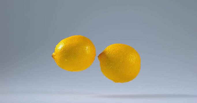 Yellow Lemons, citrus limonum, Fruits falling on Water, Slow Motion 4K