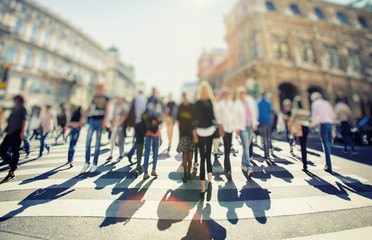 Crowd of anonymous people walking on sunset in the city streets