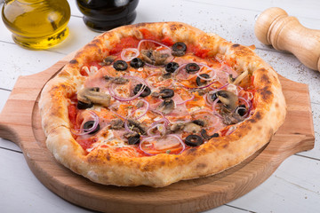 Whole baked pizza on wooden board