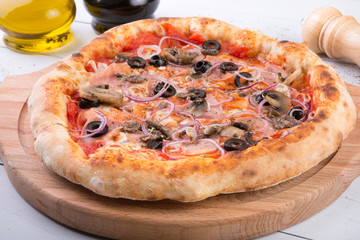 Whole baked pizza on wooden board