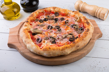 Whole baked pizza on wooden board