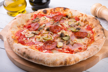 Whole baked pizza on wooden board