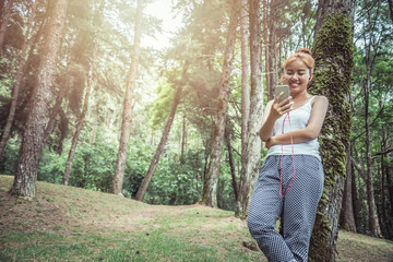 Women listen to music Relax in the nature park.