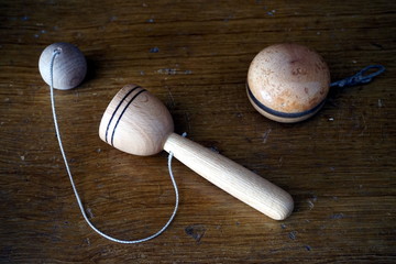 Old wooden child's toys, yoyo and ball catcher, on a vintage wooden surface