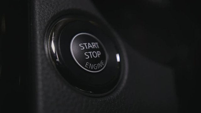 Pushing the power button to start engine.
Track in to the button. Finger to press the keyless start button to start the car engine.

