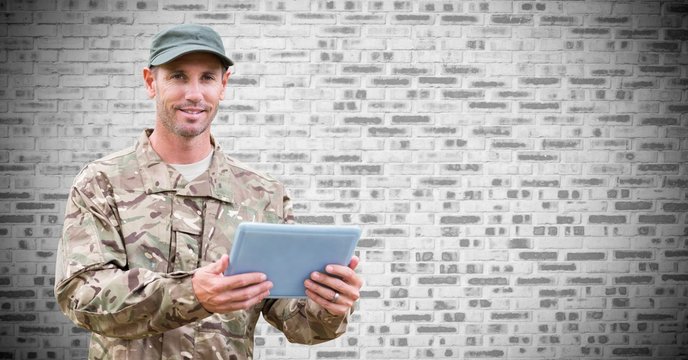 Soldier with tablet against white brick wall - Powered by Adobe