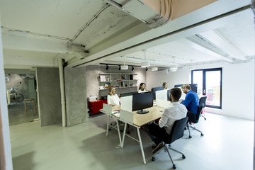 Young programmers sit and work in a modern office