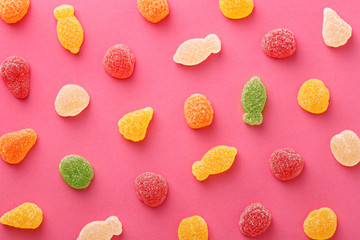 Colorful gummy candies pattern on a pink background. Soft gums in fruit shapes viewed from above. Variation concept. Top view