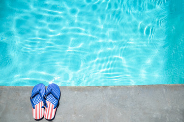Naklejka premium Summer background with flip flops near the pool