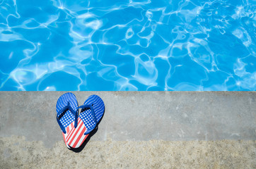 Naklejka premium Summer background with heart of flip flops near the pool