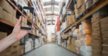 Hand photographing goods in warehouse
