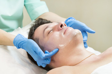 Obraz na płótnie Canvas Man in the mask cosmetic procedure in spa salon 