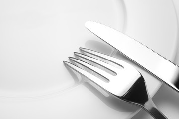 Fork and knife on a empty plate, cutlery and copy space, on a white background