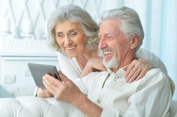 Happy elderly couple using a tablet computer