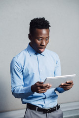 African man embarrassed looking to screen of the tablet