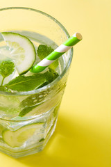 Mojito cocktail in glass on yellow background
