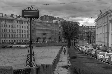 Lonely man walking on the bank of Neva river in Saint-Petersburg. Against the flow conception. Empty table with a space for text.
