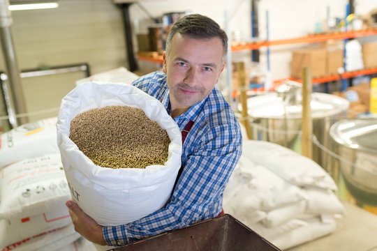 Man holding sack of grains
