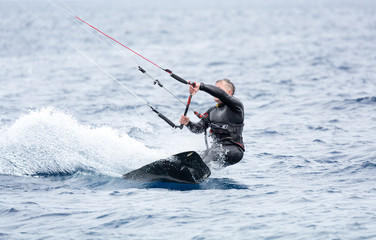 A kite surfer try to ride the waves