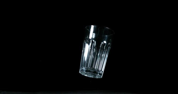 Falling Glass and Bounces on Black Background, Slow Motion 4K