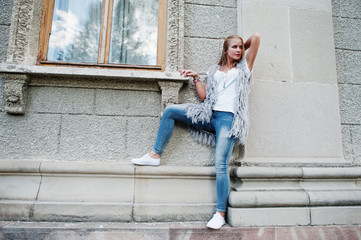 Stylish blonde woman wear at jeans and girl sleeveless with white shirt against street. Fashion urban model portrait.