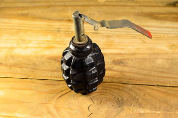 Black hand grenade on a wooden table