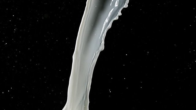 Milk spurting out against Black Background, Slow motion