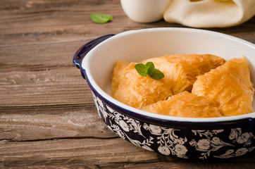 Homemade baklava stuffed cream with honey sirup on wooden table. Eastern sweets. Ramadan food